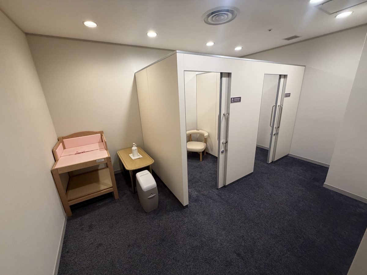 3階のベビー休憩室。手前におむつ替え台と小さなテーブル、おむつ用のごみ箱があり、奥に個室の授乳室が2つ並ぶ